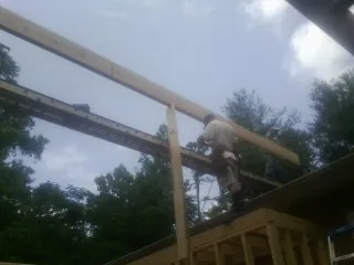 Carpenter setting a ridge beam over a new addition frame — Ice Dam Removal by Roofing Brothers in Dakota City