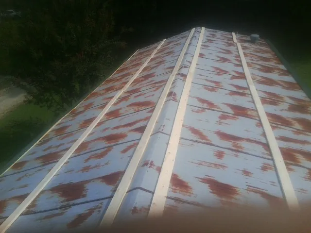 Rusted metal roof panels with new wood purlins before replacement — Storm Damage Roof Repair in Dakota City by Roofing Brothers