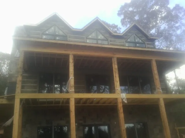 Dormers and porch framing on a large log home under construction — Roof Coating work by our crew in Dakota City
