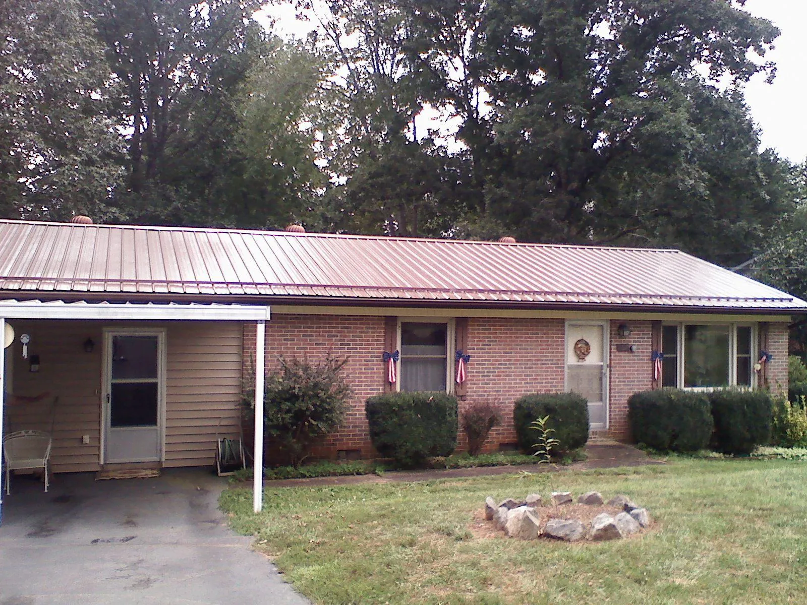 Bronze metal roof and carport on a brick ranch home — Roof Repair work by our crew in Dakota City
